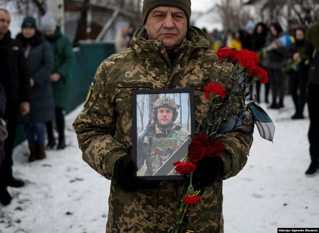 Український військовий тримає портрет побратима Володимира Андрощука, який загинув у бою під Бахмутом. Летичів Хмельницької області, 1 лютого 2023 року qxdiquiquitzrz